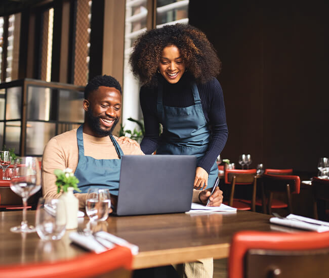 Couple looking at their SBA 7(a) loan on laptop