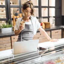 Woman reviewing finances at bakery counter