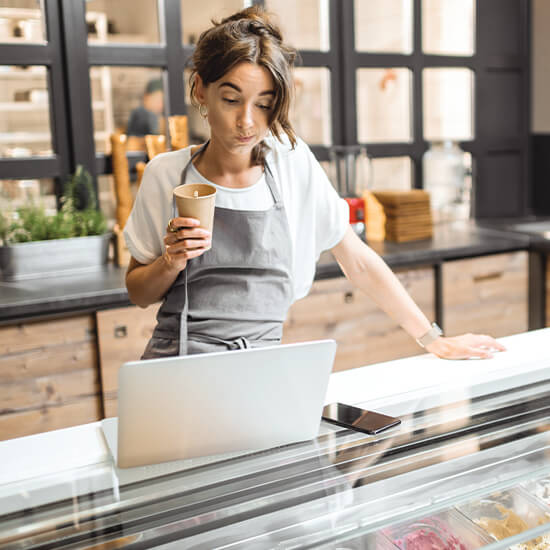 Woman reviewing finances at bakery counter