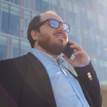 Business man outside company talking on smartphone