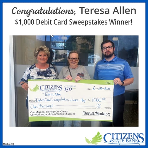 three people holding a big check