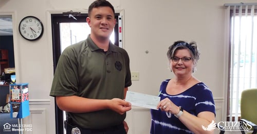 Elaina Wall presents UCI Patrolman Gavin Teeter with a check to sponsor the UCI Golf Outing